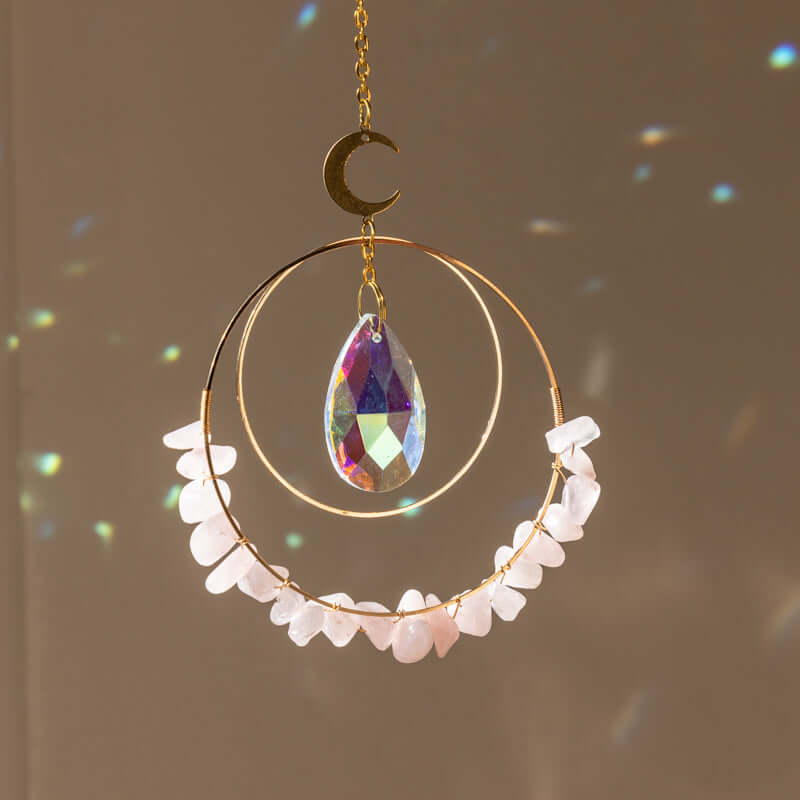 Hanging round rose quartz crystal chips suncatcher in sunlight