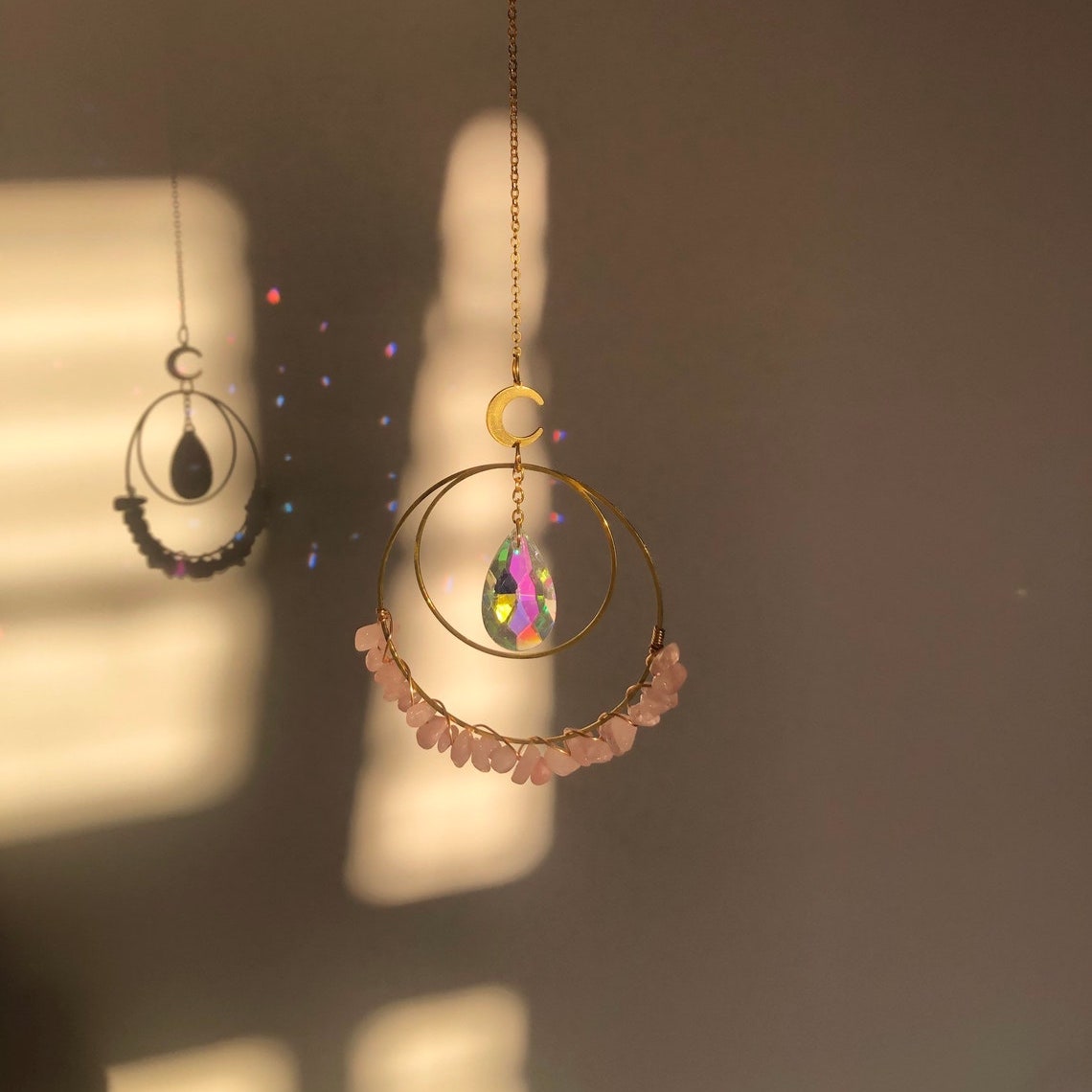 Hanging round rose quartz crystal chips suncatcher in sunlight