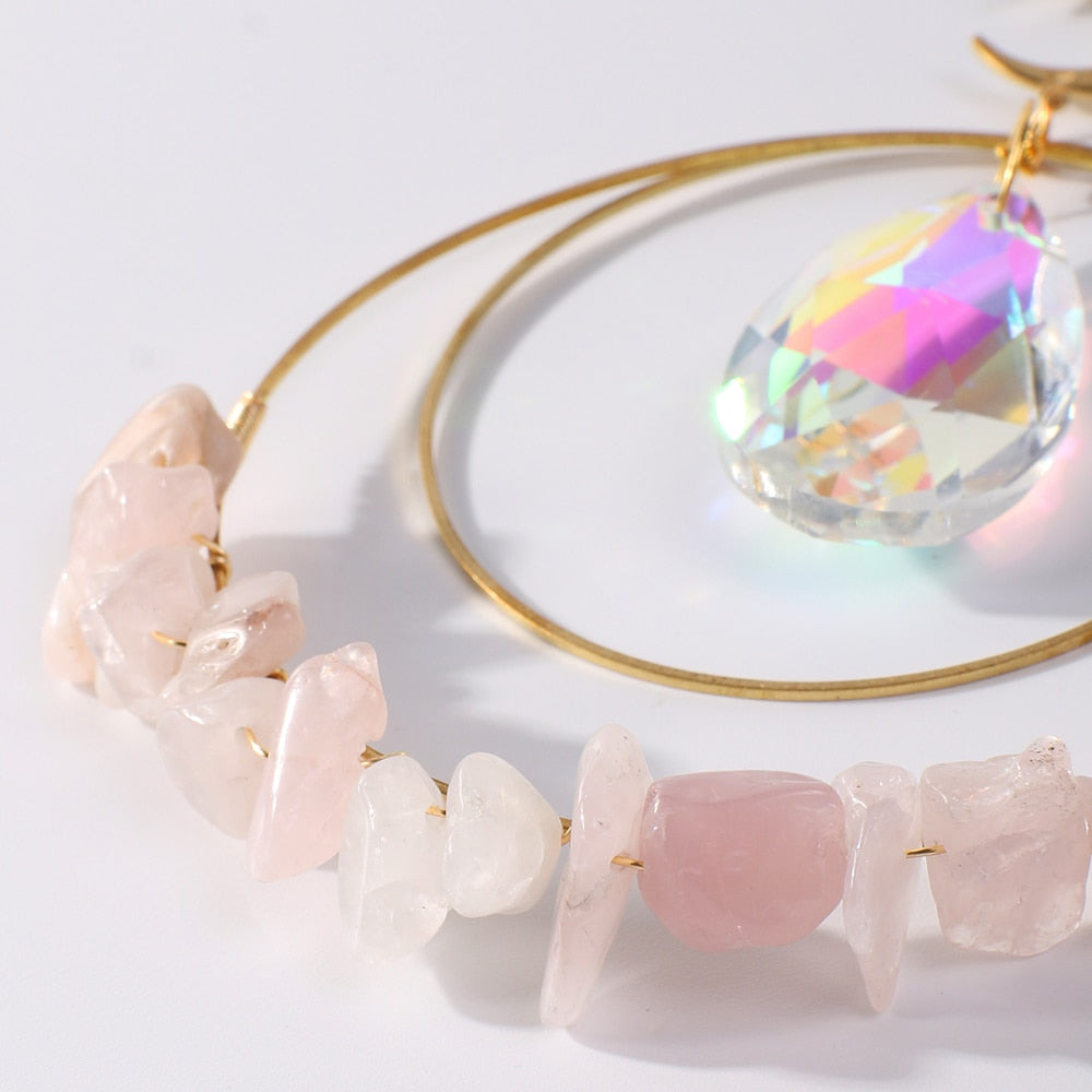 Hanging round rose quartz crystal chips suncatcher in sunlight