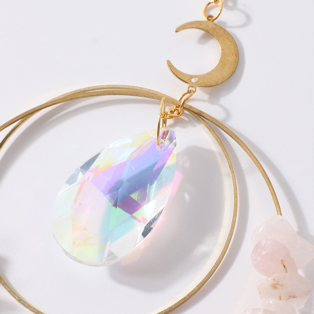 Hanging round rose quartz crystal chips suncatcher in sunlight