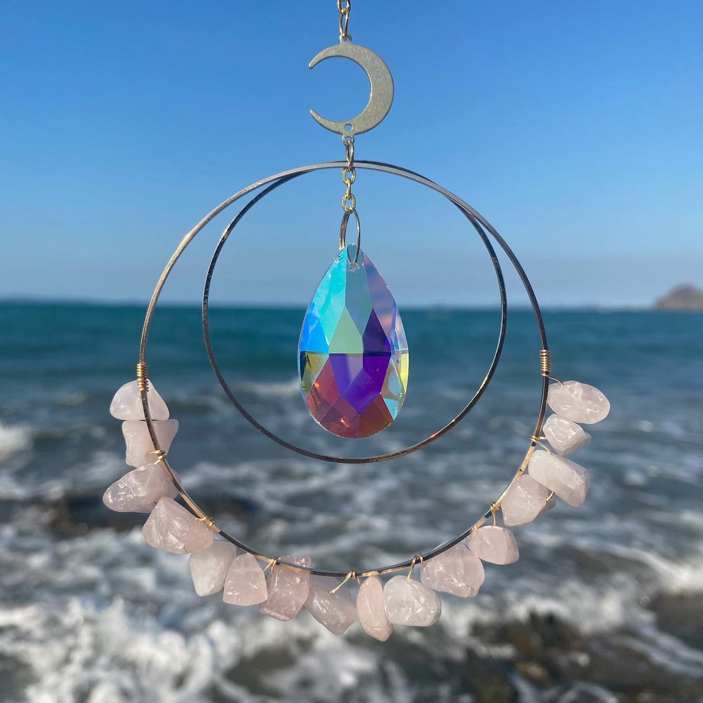 Hanging round rose quartz crystal chips suncatcher in sunlight