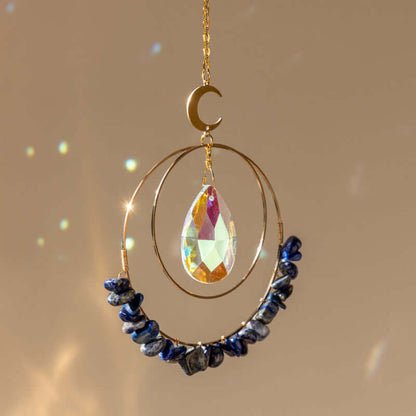 Lapis Lazuli hanging quartz crystal suncatcher in sunlight making rainbow