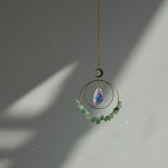 hanging Aventurine Quartz Crystal suncatcher in sunlight making rainbow