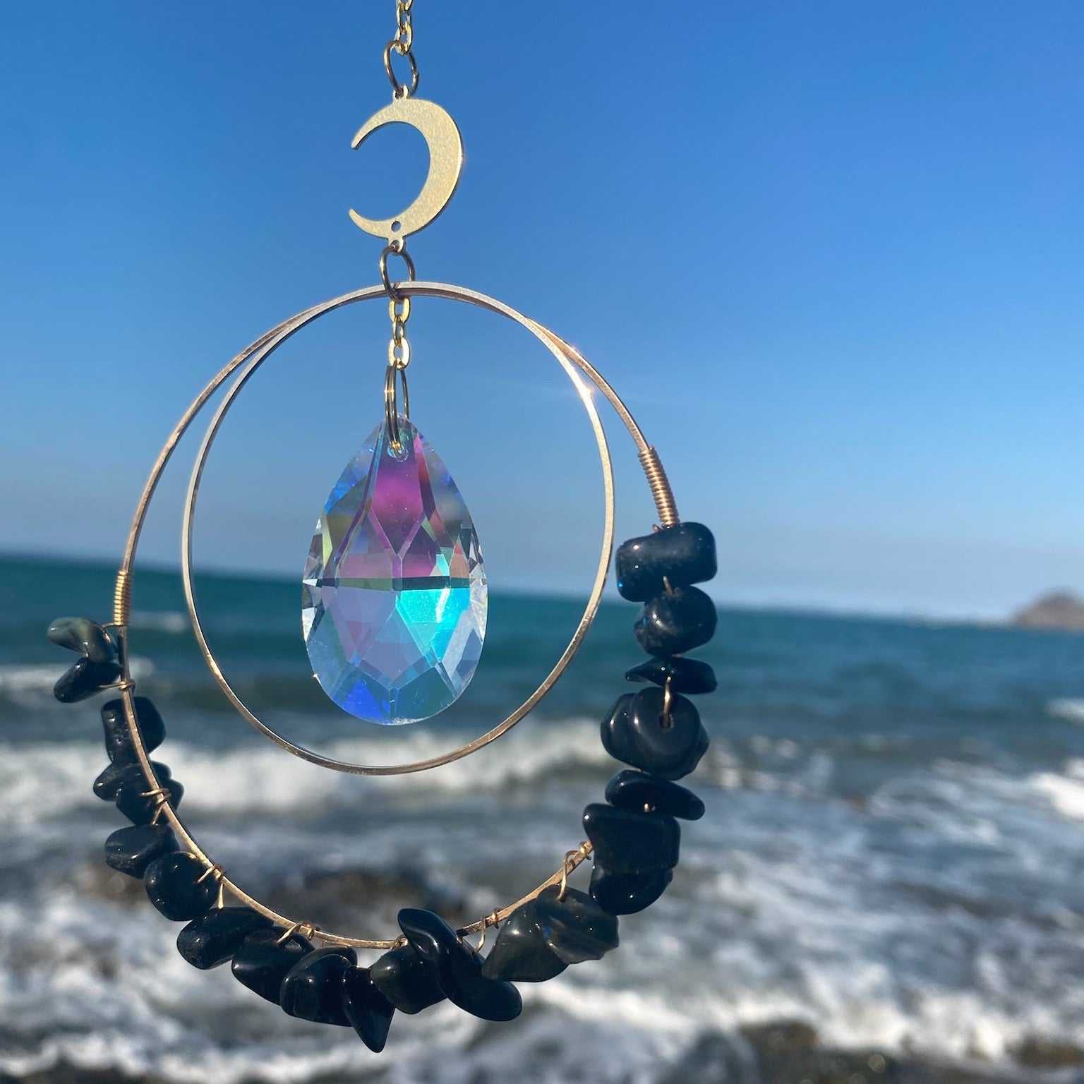 Hanging obsidian quartz crystal suncatcher in sunlight 